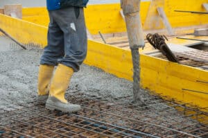 Pouring concrete on a steel iron fence.