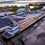 Aerial shot of plant with cargo ship in the port.