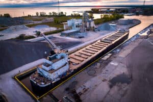 Aerial shot of plant with cargo ship in the port.