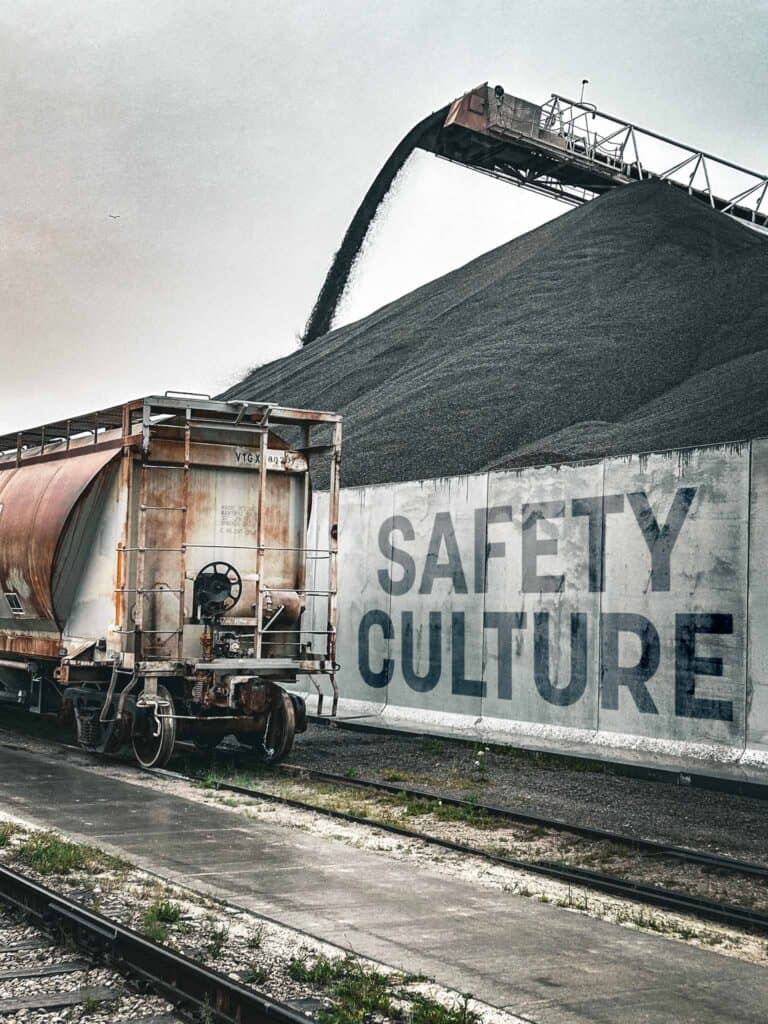 GLC Minerals plant and rail area with safety culture messaging near material handling equipment.
